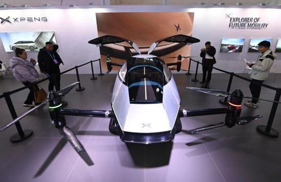 2023年12月1日，在鏈博會智能汽車鏈展區(qū)小鵬汽車展臺，參觀者觀看一臺智能飛行器。新華社記者蔡湘鑫攝