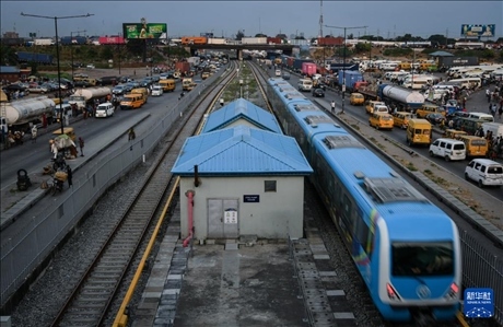 3月4日，在尼日利亞拉各斯，一列輕軌藍線列車行駛至公路交通擁堵路段附近。新華社記者 韓旭 攝