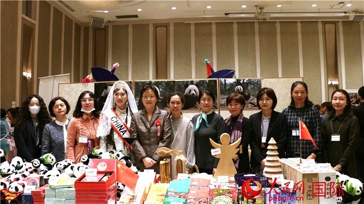 中國駐日本大使吳江浩夫人丁玥（左五）與使館人員在展位前合影留念。人民網(wǎng) 許可攝