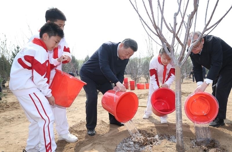 2024年4月3日，習(xí)近平總書記同少先隊(duì)員一起給剛栽下的樹苗澆水。