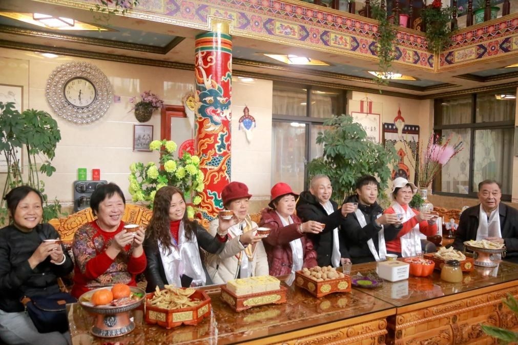 游客們?nèi)胱∶袼藓?，舉杯共飲酥油茶。新華社記者 邱星翔 攝