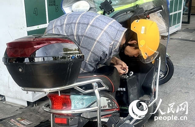 杭州一名外賣騎手正在更換共享電池。人民網(wǎng)記者 張麗瑋攝