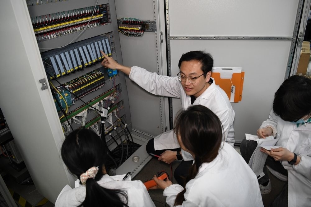 2024年4月6日，在位于安徽合肥的中國(guó)科學(xué)技術(shù)大學(xué)，安徽省先進(jìn)功能高分子薄膜工程實(shí)驗(yàn)室團(tuán)隊(duì)成員在檢修自主研制的高分子薄膜原位雙向拉伸實(shí)驗(yàn)設(shè)備的電氣控制系統(tǒng)。