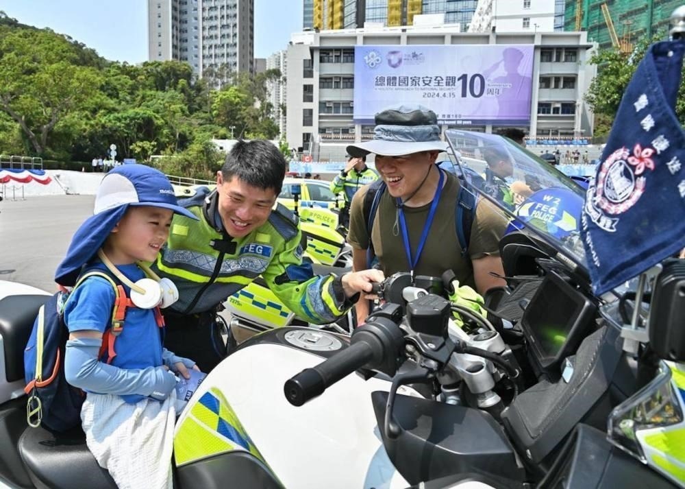 △2024年4月13日，香港特區(qū)政府警務處舉行“全民國家安全教育日”暨香港警察學院開放日開幕典禮。這是13日當天，警隊護送組人員現(xiàn)場向市民介紹其工作。