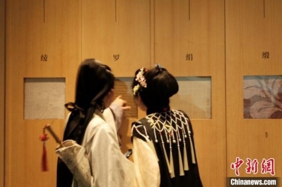 身著漢服的年輕人在中國(guó)絲綢博物館里看展。毛瑜 攝