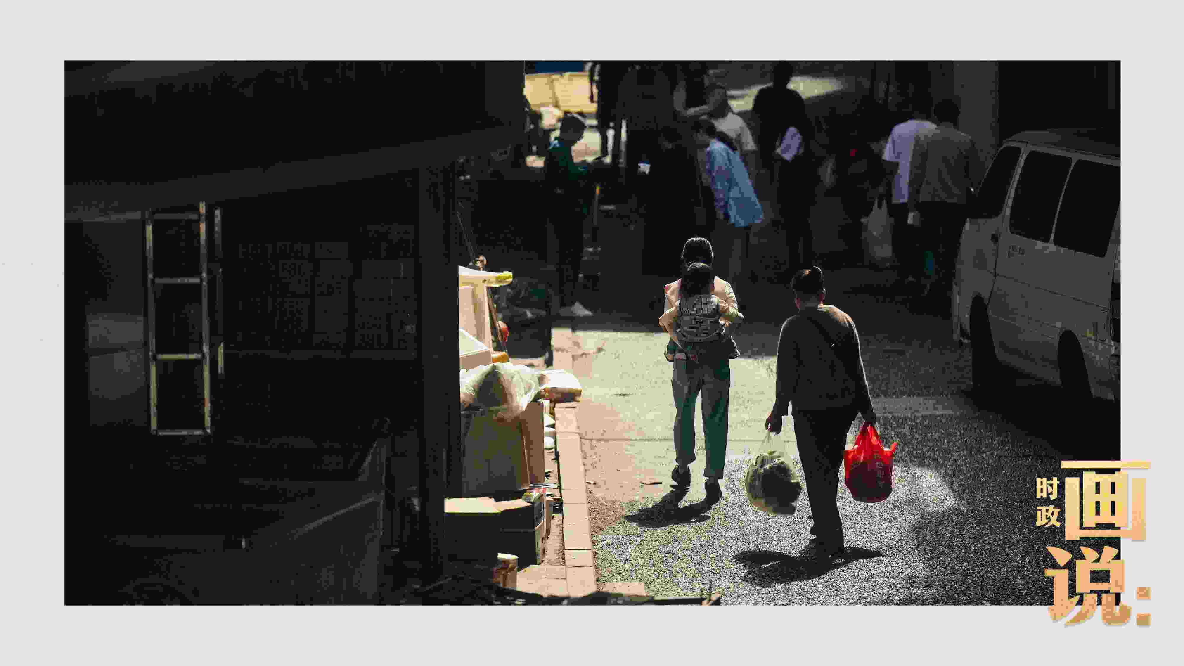 △老城區(qū)鱗次的樓宇間漏下一縷光，路人走過(guò)暖陽(yáng)。