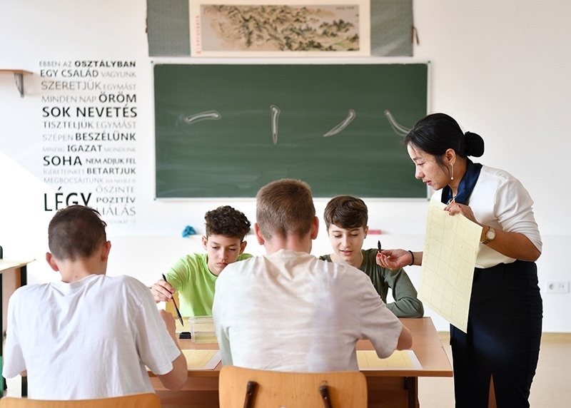 2023年2月24日，在匈牙利首都布達佩斯的匈中雙語學校，中國教師指導學生們學習書法。