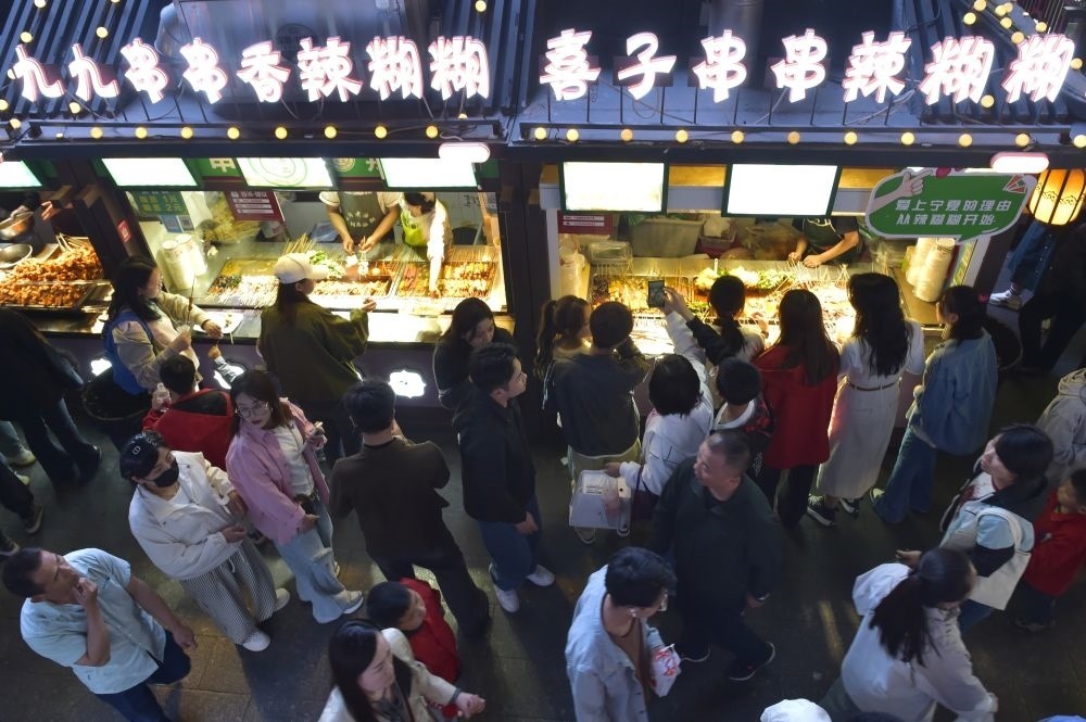 2024年5月4日，游客在寧夏銀川懷遠(yuǎn)夜市品嘗當(dāng)?shù)鼐W(wǎng)紅美食辣糊糊。新華社記者 毛竹 攝