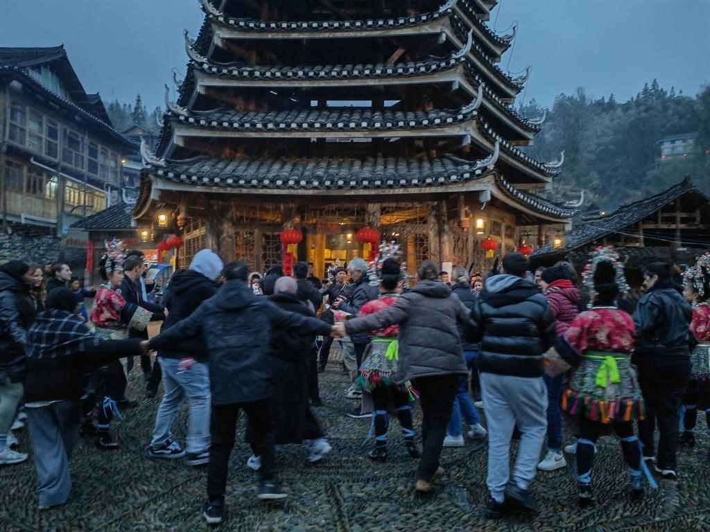 法國(guó)青年與當(dāng)?shù)卮迕駹渴痔?。新華社記者 羅羽 攝