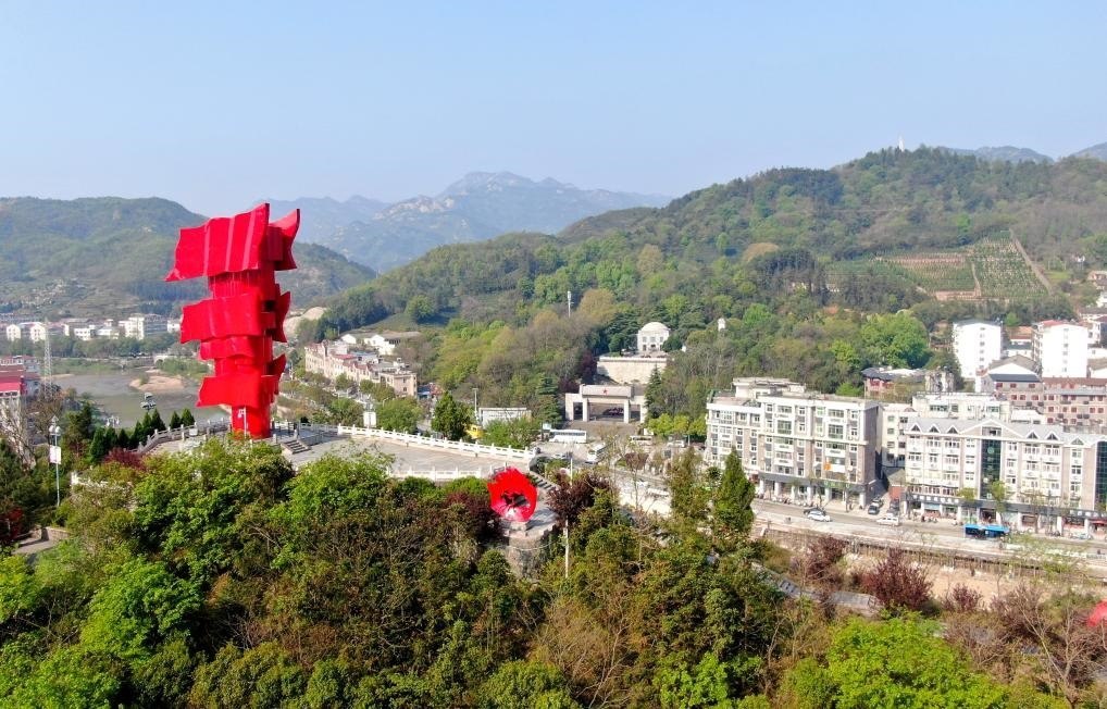 這是2021年4月9日拍攝的鄂豫皖蘇區(qū)首府革命博物館附近的英雄山上的“紅旗飄飄”主題雕塑（無人機(jī)照片）。新華社發(fā)