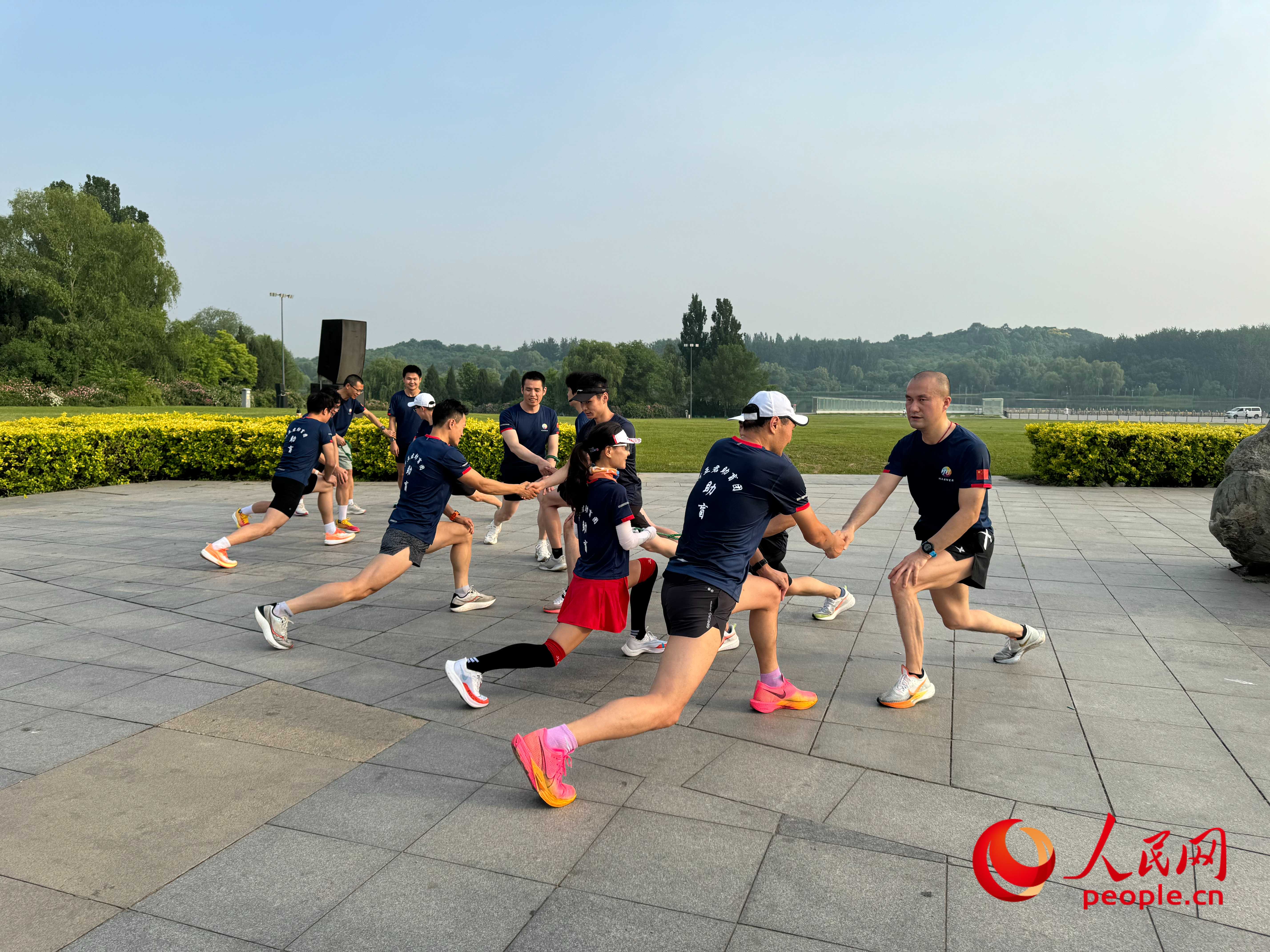 盲人和志愿者做跑步前準(zhǔn)備。人民網(wǎng) 周靜圓攝