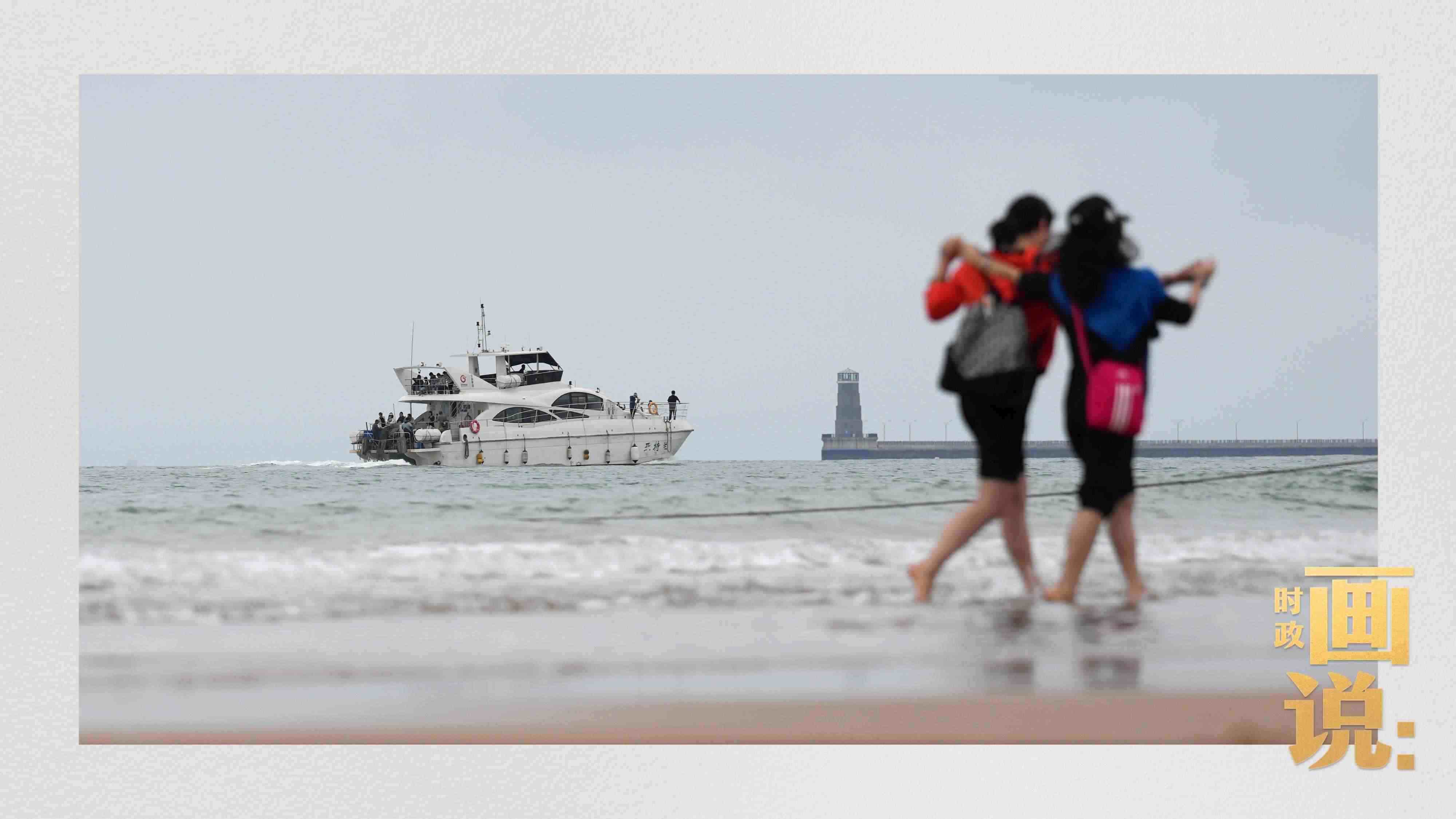 △日照陽光海岸綠道上的萬平口景區(qū)，一對(duì)游客在海浪中翩然起舞。