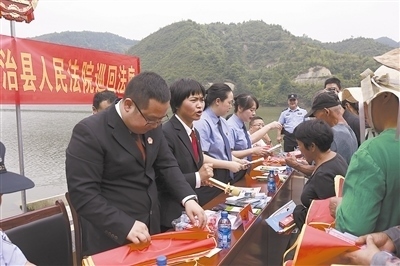 法院干警及相關(guān)部門工作人員對群眾進(jìn)行生態(tài)環(huán)境保護(hù)普法教育。