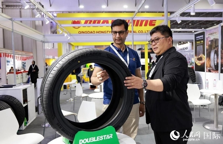 工作人員向客戶展示雙星電動汽車輪胎。和傳統(tǒng)汽車輪胎相比，電動汽車輪胎具有更高承載能力、更加靜音舒適、更好極速抓地、更低滾動阻力等特點。人民網(wǎng)記者 管克江攝