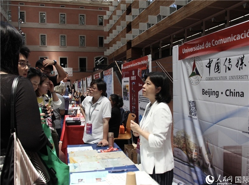 旅西華人華僑在展臺前咨詢。人民網(wǎng)記者 許海林攝