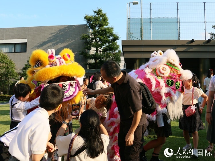 孩子們好奇地圍觀舞獅。人民網(wǎng) 許可攝