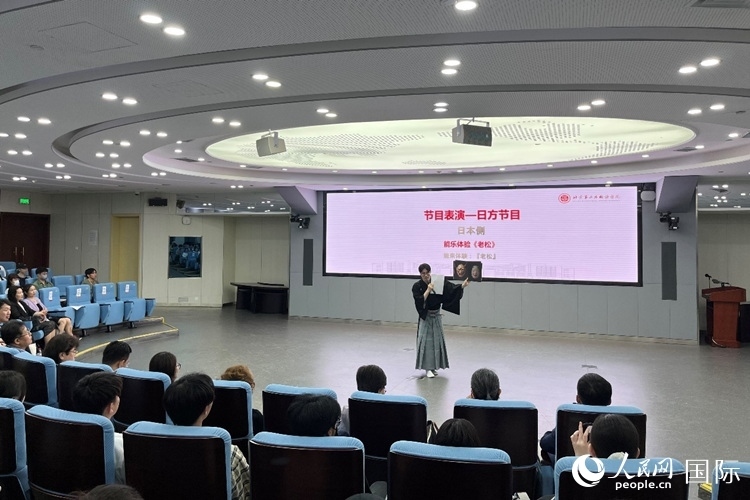日本大學(xué)生介紹能樂知識(shí)。人民網(wǎng)記者 陳思攝