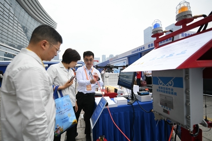 6月16日，在全國“安全宣傳咨詢?nèi)铡敝鲌?chǎng)活動(dòng)上，四川省安全科學(xué)技術(shù)研究院工作人員（右一）向參觀者介紹“有限空間作業(yè)實(shí)時(shí)風(fēng)險(xiǎn)管控系統(tǒng)”。新華社記者胥冰潔攝