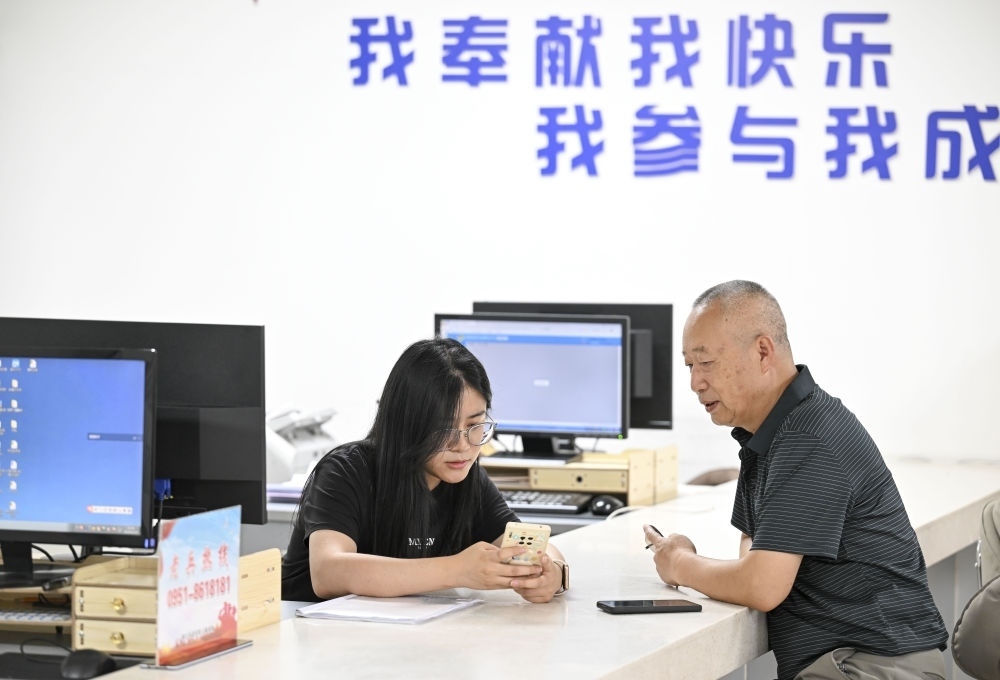 6月20日，在長(zhǎng)城花園社區(qū)黨群服務(wù)中心，工作人員幫助居民辦理業(yè)務(wù)。
