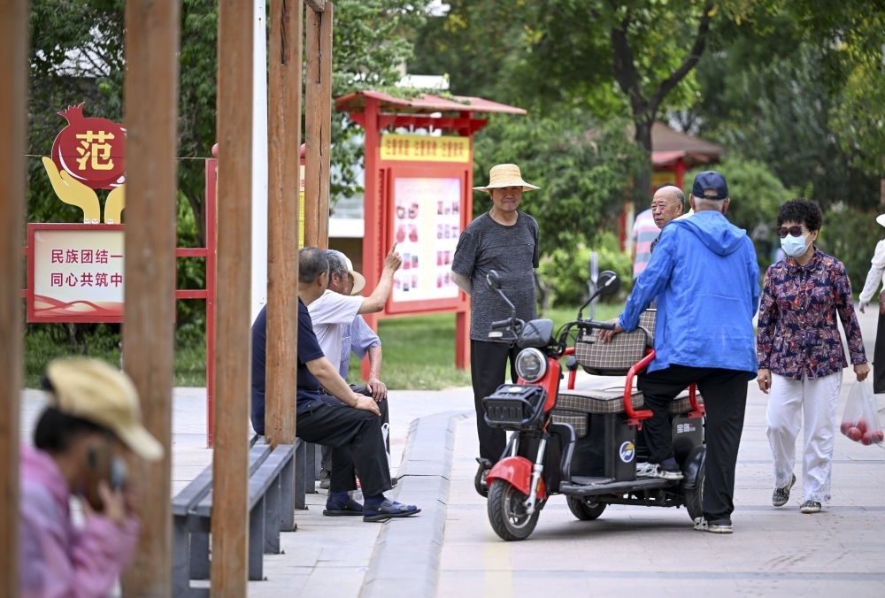 6月20日，長(zhǎng)城花園社區(qū)的居民在休閑、聊天。