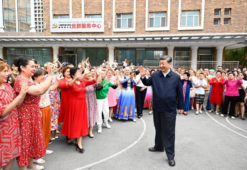 2022年7月13日，習(xí)近平總書記在新疆烏魯木齊市天山區(qū)固原巷社區(qū)考察時，向各族群眾揮手致意。