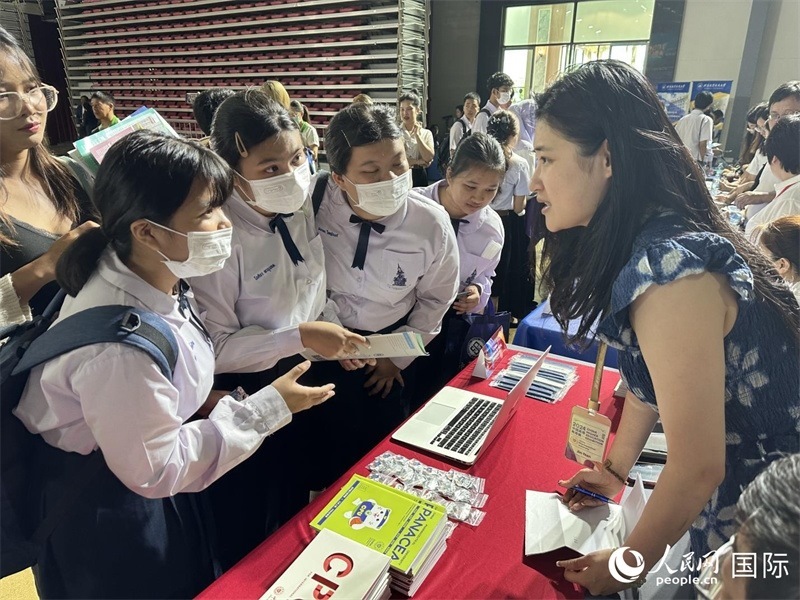 來自泰國的學生、家長在教育展臺前咨詢。人民網(wǎng)記者 簡承淵攝