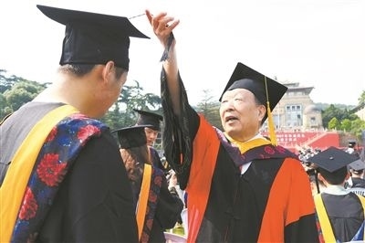 2017年6月22日，李德仁（右一）參加武漢大學(xué)畢業(yè)典禮并為畢業(yè)生撥穗。