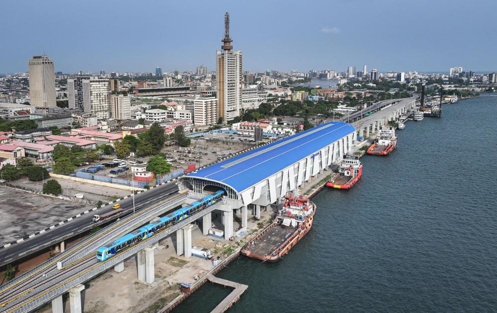 2024年3月2日，在尼日利亞拉各斯，一列輕軌藍(lán)線列車(chē)駛?cè)氪a頭站（無(wú)人機(jī)照片）。拉各斯輕軌藍(lán)線是西非地區(qū)首條由中國(guó)企業(yè)自主設(shè)計(jì)、建造、施工、運(yùn)營(yíng)的電氣化城市軌道交通項(xiàng)目。新華社記者 韓旭 攝
