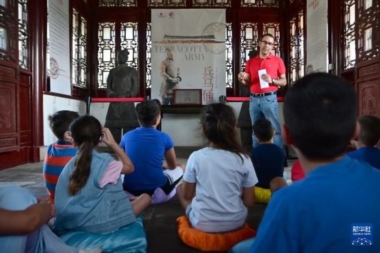 7月4日，在馬耳他桑塔露琪亞市的中國古典園林“靜園”，人們聆聽關(guān)于兵馬俑的講解。新華社發(fā)（喬納森·博格 攝）