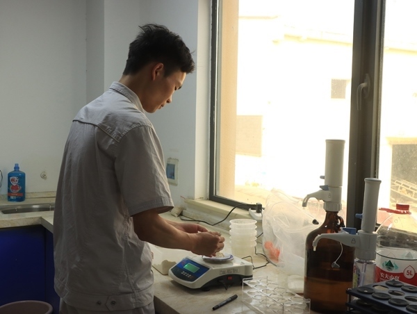 武漢直屬庫租倉點質(zhì)檢員正在對小麥進(jìn)行質(zhì)量檢測。受訪者供圖