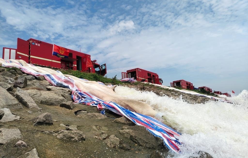 7月14日，株洲消防救援支隊消防員正在團洲垸洞庭湖大堤開展排澇作業(yè)。（湖南省消防救援總隊供圖）