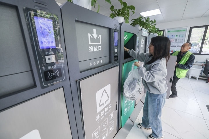 2024年4月10日，在浙江省湖州市吳興區(qū)飛英街道新華府小區(qū)內(nèi)，居民在垃圾分類智能系統(tǒng)的指導(dǎo)下進行垃圾分類投放，居民的投放情況將實時匯總到智慧服務(wù)平臺，會有相應(yīng)的積分獎勵。新華社記者 徐昱 攝