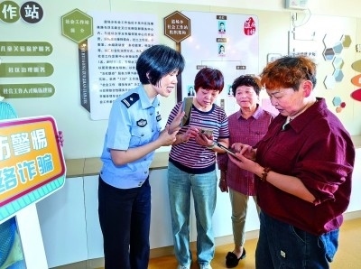 浙江湖州民警指導(dǎo)居民加入湖州“e企安”微信群，實(shí)時(shí)接收反詐信息。新華社發(fā)