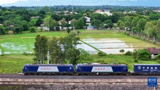 8月5日，由老撾籍火車司機(jī)獨(dú)立駕駛的滿載貨物的列車駛出萬象站，向中國昆明進(jìn)發(fā)（無人機(jī)照片）。新華社發(fā)（楊永全 攝）