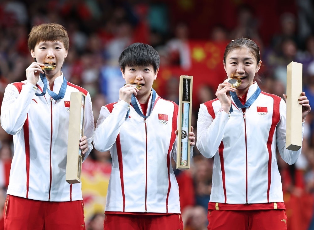 冠軍中國隊選手王曼昱、孫穎莎、陳夢（從左至右）在巴黎奧運會乒乓球女子團體頒獎儀式上（2024年8月10日攝）。新華社記者 王東震 攝