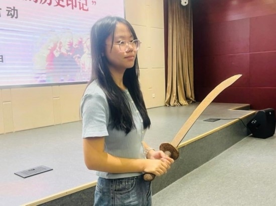 圖為南開大學社會實踐隊學生代表呼月紅在學術交流活動現(xiàn)場，展示河間調(diào)研行中獲贈的一戰(zhàn)華工蔡世春曾使用過的一把大刀。林卓瑋 攝