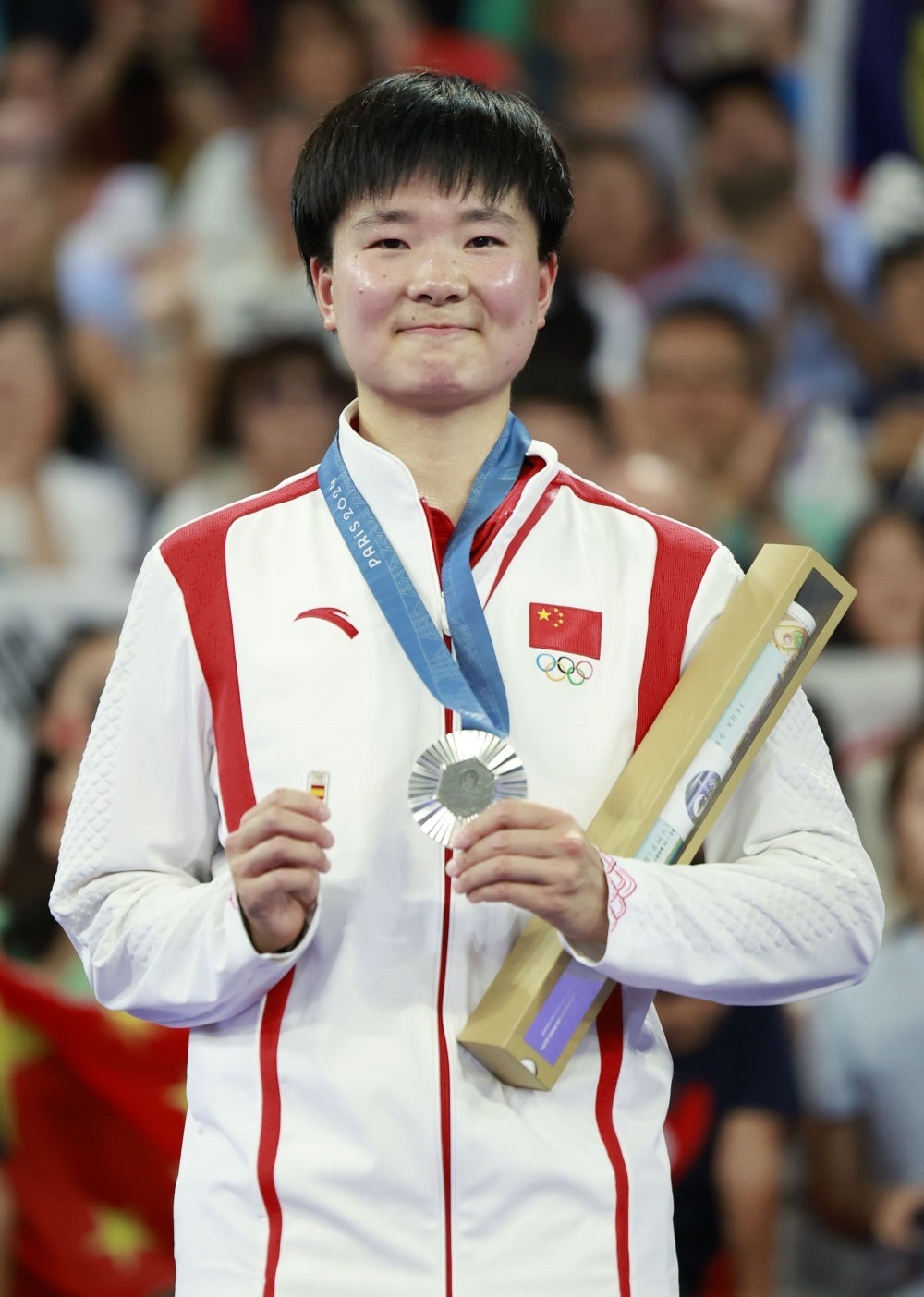 巴黎奧運會羽毛球女子單打亞軍、中國選手何冰嬌在頒獎儀式上一手握著銀牌，一手握著西班牙奧委會徽章（2024年8月5日攝）。新華社記者 任正來 攝