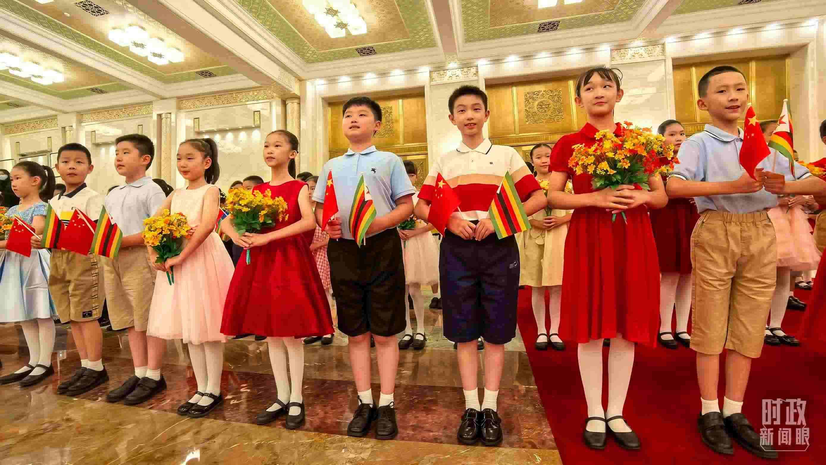 △現(xiàn)場歡迎津巴布韋總統(tǒng)訪華的青少年。（總臺央視記者鐘銳拍攝）