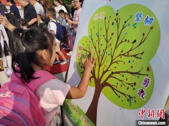 圖為衡水市利民路小學(xué)，孩子們?cè)诔砷L(zhǎng)樹(shù)的“好習(xí)慣”樹(shù)枝上按手印做出承諾。張松 攝