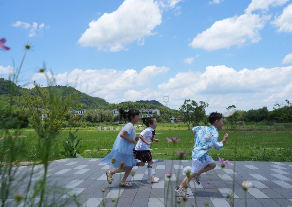 兒童在余姚市梁弄鎮(zhèn)的田野間奔跑（7月3日攝）。新華社記者翁忻旸 攝