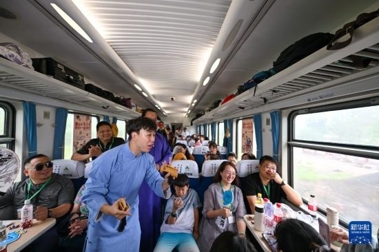 9月7日，相聲演員在S910列車上為旅客表演快板。