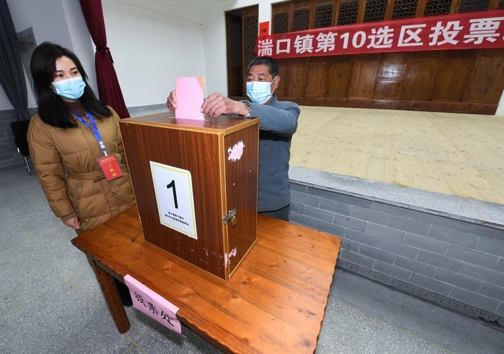 2021年12月14日，在浙江省杭州市臨安區(qū)湍口鎮(zhèn)迎豐村的基層投票點，村民在參加投票，村級監(jiān)察聯(lián)絡(luò)員監(jiān)票。新華社記者 徐昱 攝