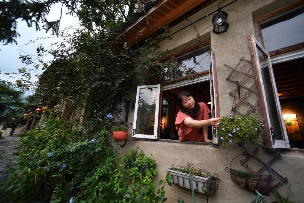 8月29日，在福建省屏南縣熙嶺鄉(xiāng)，龍?zhí)洞濉靶麓迕瘛泵泛暝诖蚶碜约航?jīng)營(yíng)的民宿外墻裝飾花盆。新華社記者姜克紅 攝