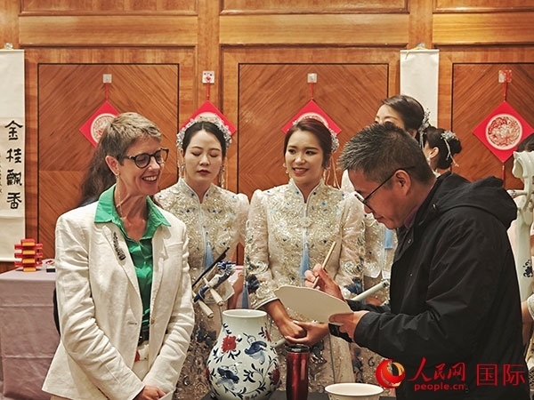 現(xiàn)場(chǎng)的非遺傳承人為英國(guó)觀眾展示畫技。人民網(wǎng)記者 邢雪攝