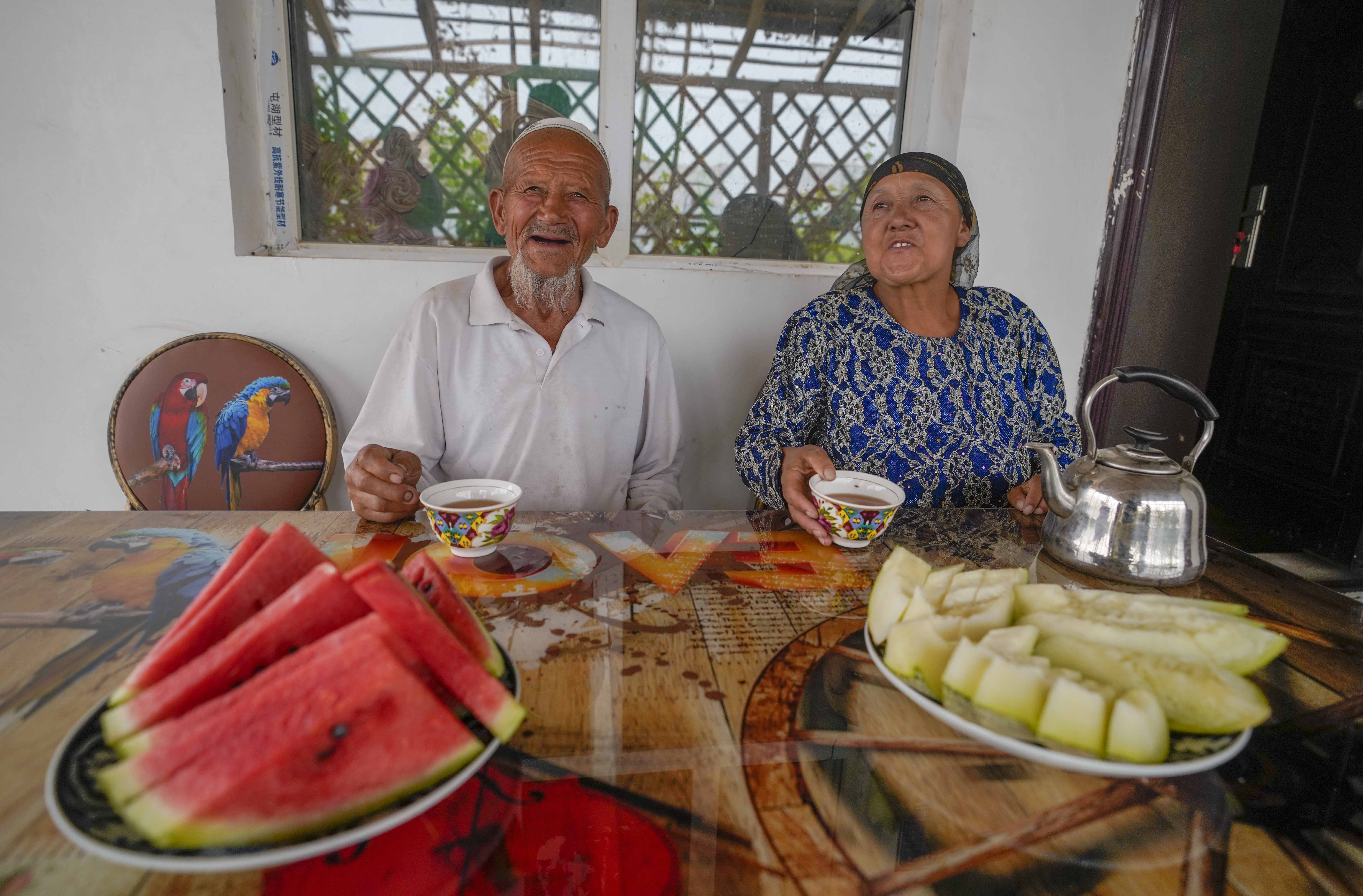 在新疆喀什地區(qū)伽師縣江巴孜鄉(xiāng)依帕克其村57號，80歲的維吾爾族老人伊米提·艾山（左）在自家庭院中（2020年6月8日攝）。