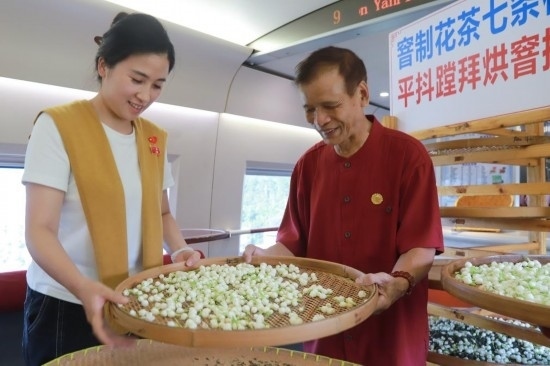 10月1日，福州市茉莉花茶窨制工藝代表性傳承人張子建與旅客在G1634次列車上制作茉莉花茶。新華社記者周義 攝