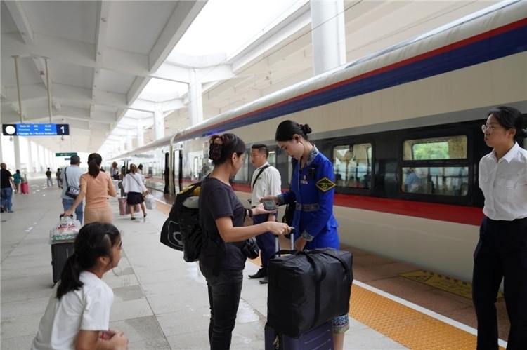 中老鐵路工作人員在站臺指引旅客進站乘車。老中鐵路有限公司供圖