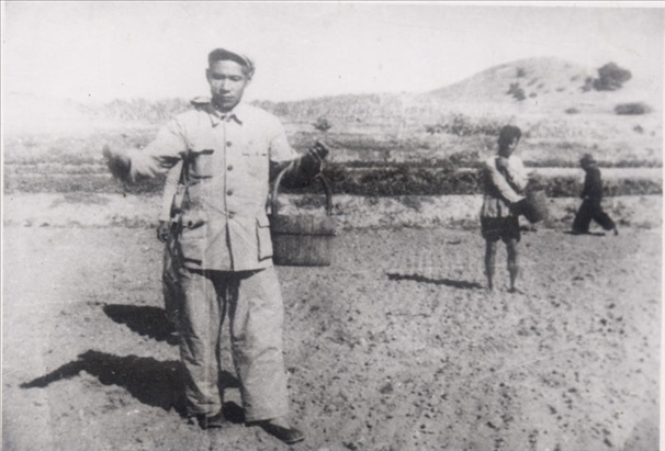 谷文昌（左）在田間與農(nóng)民一起勞動(dòng)（資料照片）。