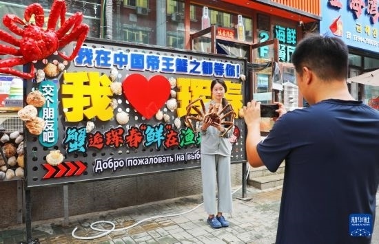 9月21日，游客在吉林省琿春市一處帝王蟹元素主題裝飾前拍照留念。新華社發(fā)