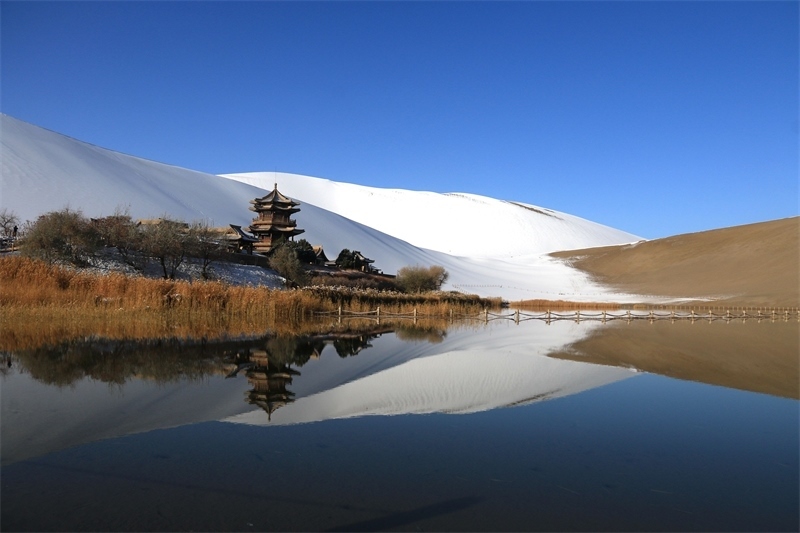 鳴沙山月牙泉景區(qū)雪景。敦煌市委宣傳部供圖，張曉亮攝